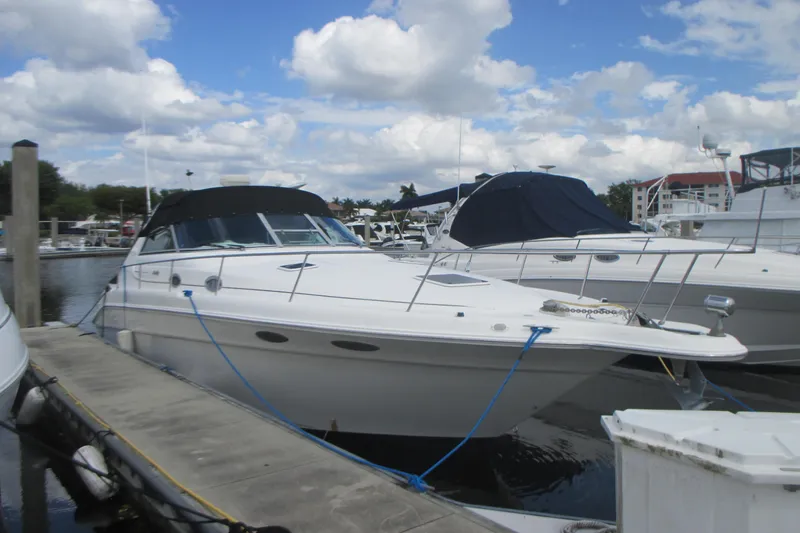 Slide: The Image of 1997 Sea Ray Sundancer 330 docked at marina under cloudy sky. - 2