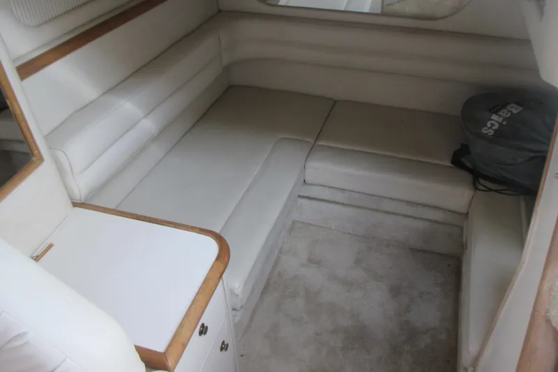 Slide: The Image of 1997 Sea Ray Sundancer 330 cabin interior with beige seating and compact table. - 21