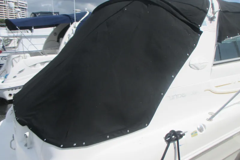Slide: The Image of 1997 Sea Ray Sundancer 330 with black cover docked at marina. - 3