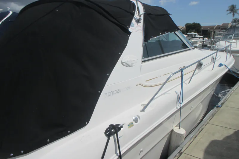 Slide: The Image of 1997 Sea Ray Sundancer 330 docked, featuring black canopy and sleek white hull. - 4