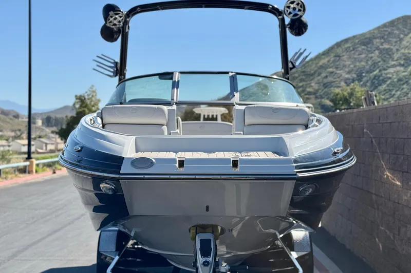 Slide: The Image of 2020 Crownline Eclipse E255 SURF boat on trailer, scenic mountain backdrop. - 2