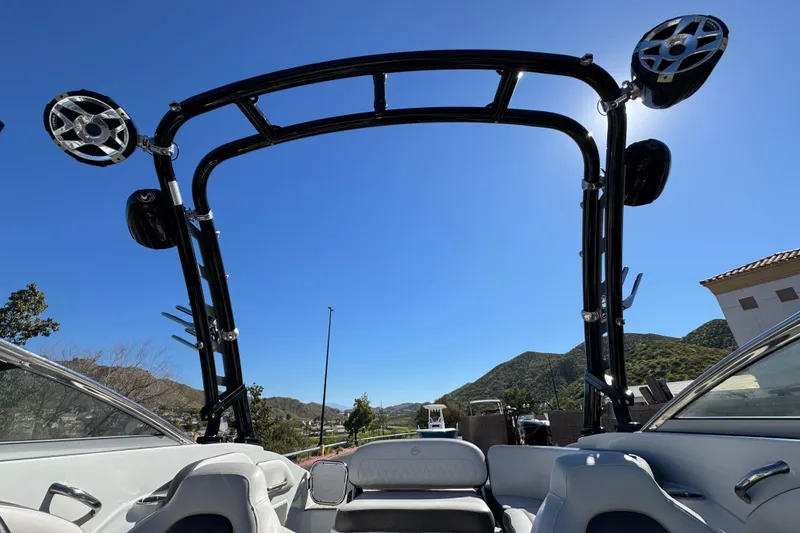 Slide: The Image of 2020 Crownline Eclipse E255 SURF boat interior with wakeboard tower against blue sky. - 20