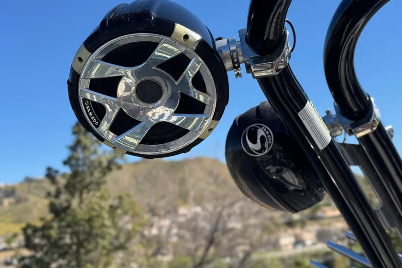 Slide: The Image of 2020 Crownline Eclipse E255 SURF boat speakers against a clear blue sky. - 21