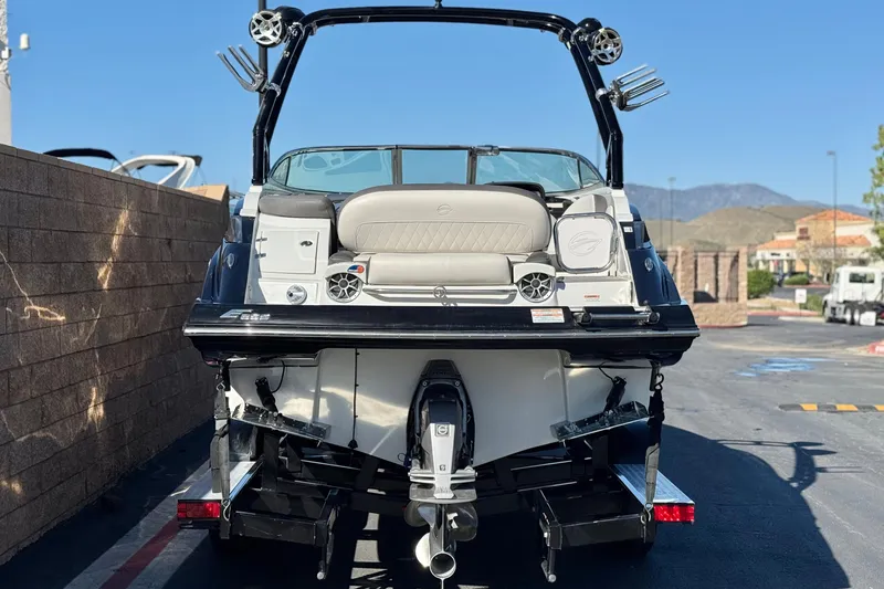 Slide: The Image of 2020 Crownline Eclipse E255 SURF boat, rear view, parked outdoors. - 4