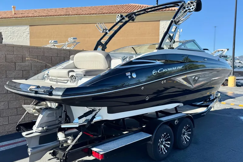 Slide: The Image of 2020 Crownline Eclipse E255 SURF boat on trailer, sleek black design, parked outdoors. - 5