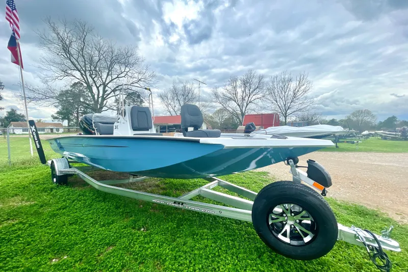 The Image of 2026 Xpress H20B Bay boat on trailer, parked on grass under cloudy sky. - 1
