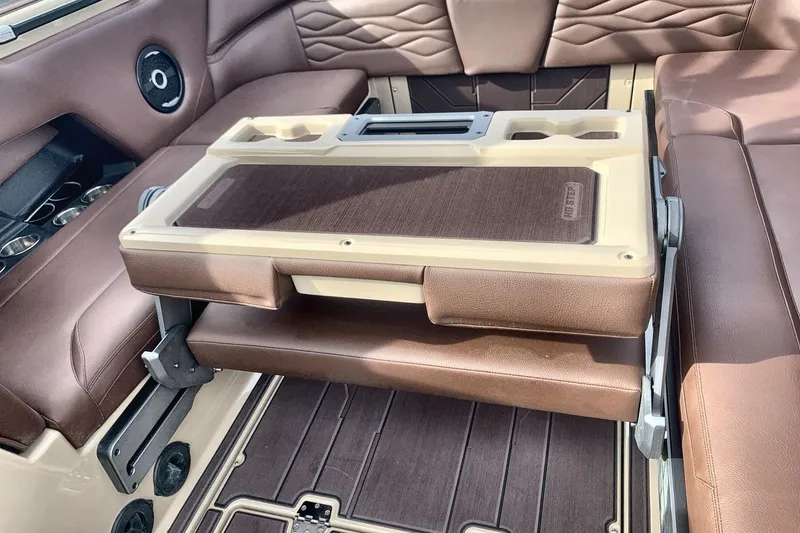 Slide: The Image of 2026 Supra SE 550 interior with brown leather seating and foldable table. - 21