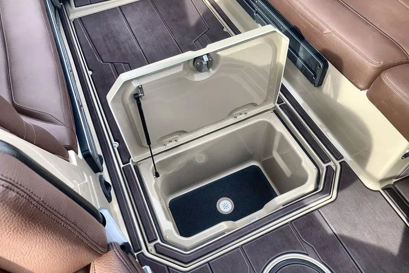 Slide: The Image of 2026 Supra SE 550 boat interior with open storage compartment and brown seating. - 25