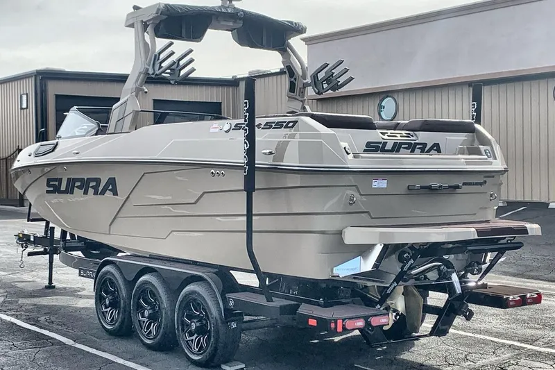 Slide: The Image of 2026 Supra SE 550 boat on trailer, parked outdoors, showcasing sleek design and modern features. - 5