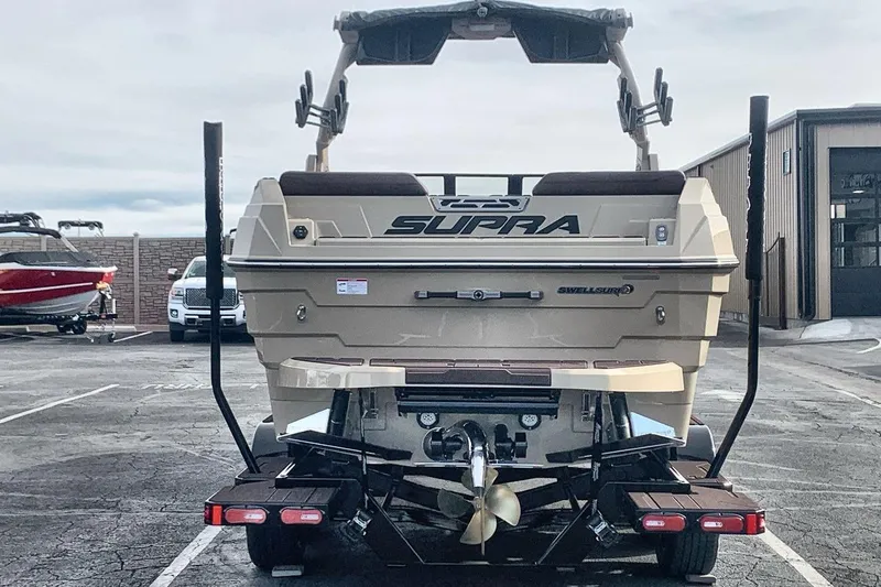 Slide: The Image of 2026 Supra SE 550 boat on trailer, rear view in parking lot. - 6
