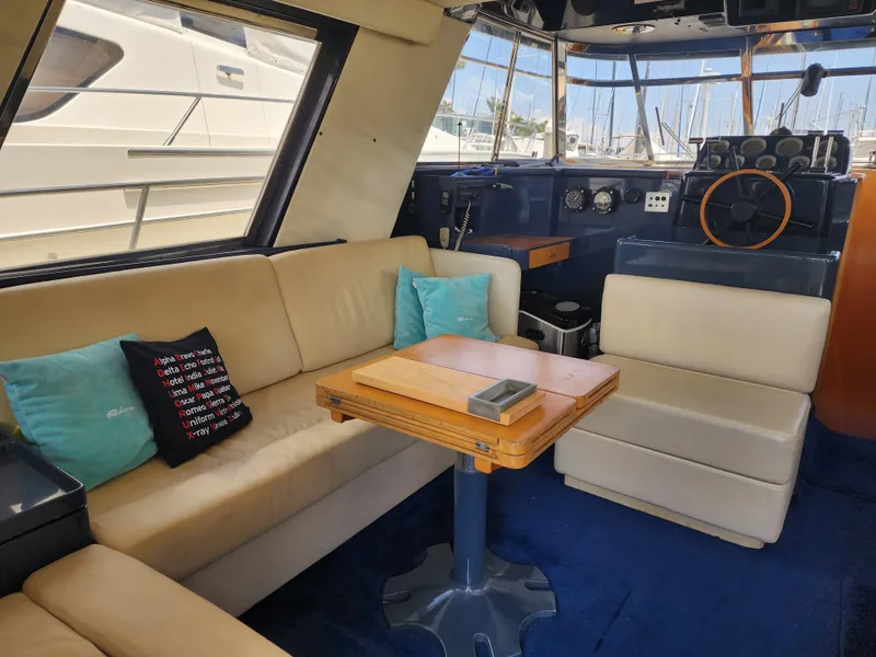 Slide: The Image of Interior of a 1987 Riva SuperAmerica yacht with beige seating and a wooden table. - 10