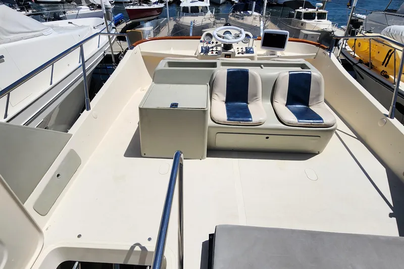 Slide: The Image of 1987 Riva SuperAmerica yacht deck with dual seats and control panel, docked at marina. - 31