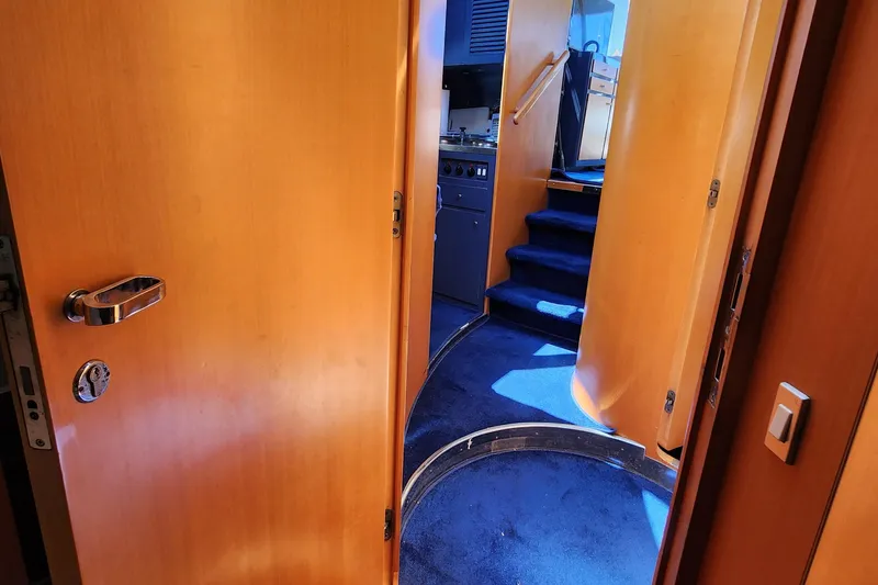 Slide: The Image of 1987 Riva SuperAmerica yacht interior with wooden doors and blue carpeted stairs. - 14