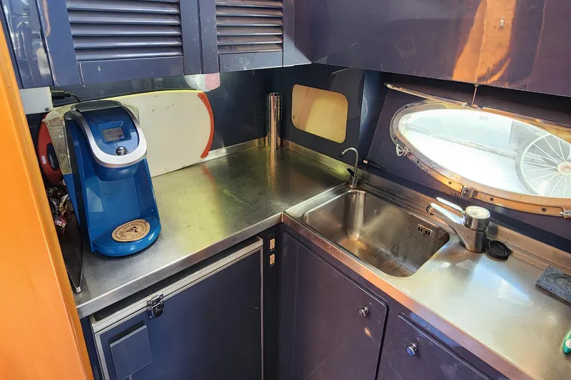 Slide: The Image of 1987 Riva SuperAmerica yacht kitchen with stainless steel counter, sink, and coffee maker. - 15