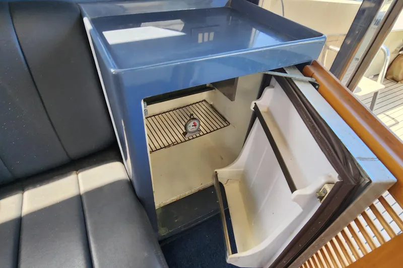 Slide: The Image of Open mini fridge on 1987 Riva SuperAmerica yacht, showcasing interior shelving. - 17
