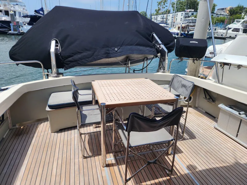 Slide: The Image of 1987 Riva SuperAmerica yacht deck with table and chairs, docked at marina. - 38