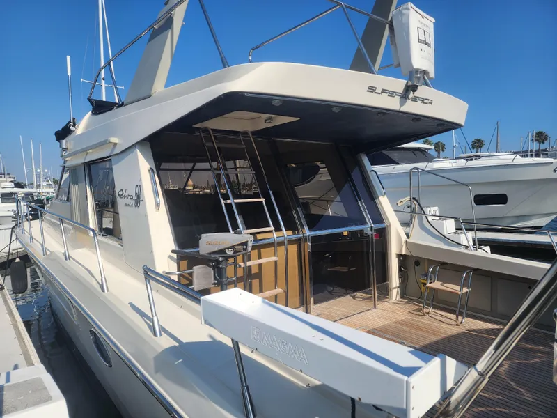 Slide: The Image of 1987 Riva SuperAmerica yacht docked at marina, showcasing elegant design and spacious deck. - 45