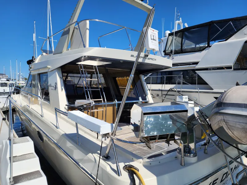 Slide: The Image of 1987 Riva SuperAmerica yacht docked at marina, showcasing sleek design and spacious deck. - 50