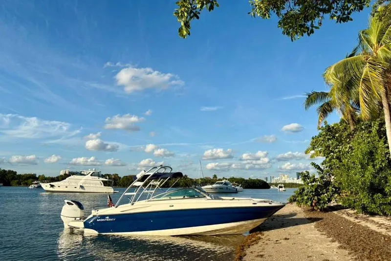 The Image of 2009 Monterey 278 SSC boat on trailer, blue and white design, parked outdoors. - 0
