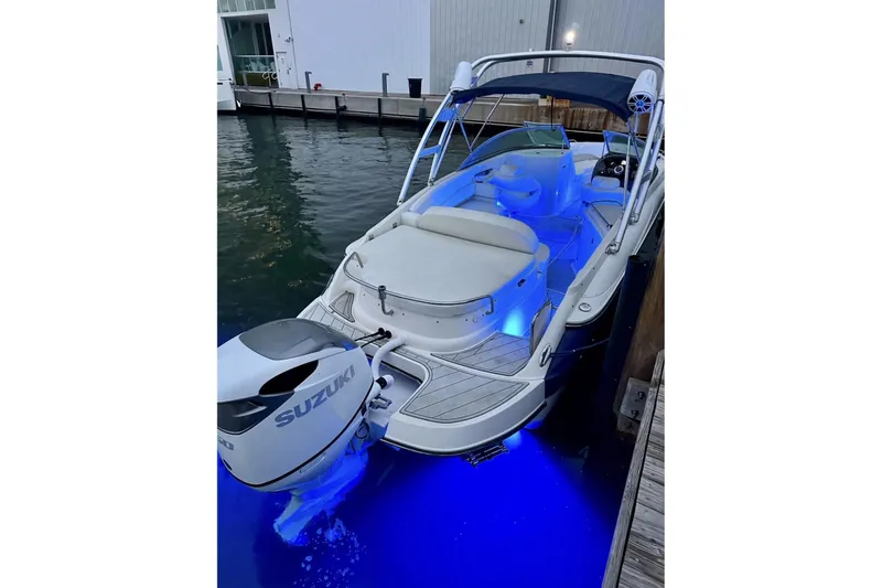 Slide: The Image of 2009 Monterrey 278s boat with Suzuki engine, docked, featuring blue LED lighting. - 14