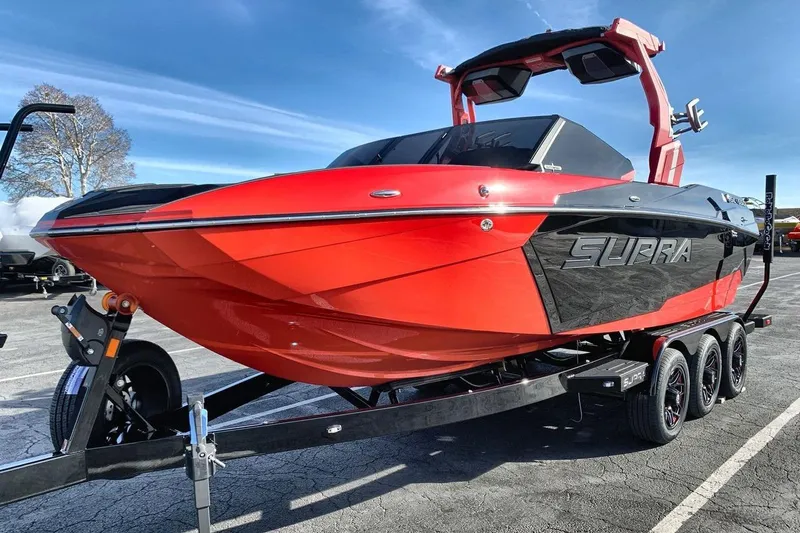 The Image of 2026 Supra SL 550 boat in vibrant red and black on a trailer. - 1