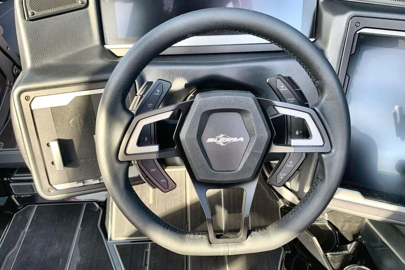 Slide: The Image of Steering wheel of 2026 Supra SL 550 with modern controls and sleek design. - 14