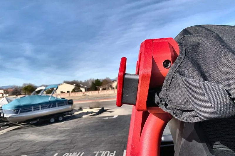 Slide: The Image of Red car seat detail with a covered boat in the background, clear sky above. - 26