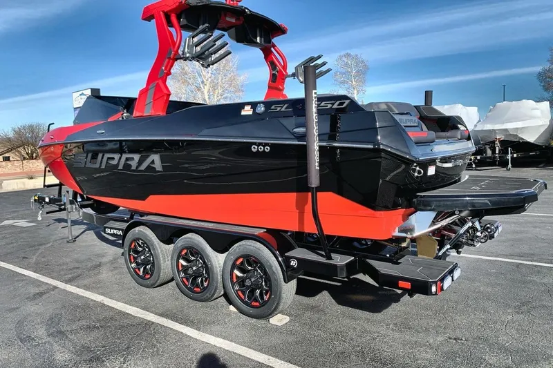 Slide: The Image of 2026 Supra SL 550 boat with red and black design on a trailer. - 3