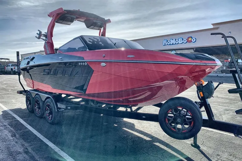 Slide: The Image of 2026 Supra SL 550 boat on trailer, red and black design, parked outdoors. - 7