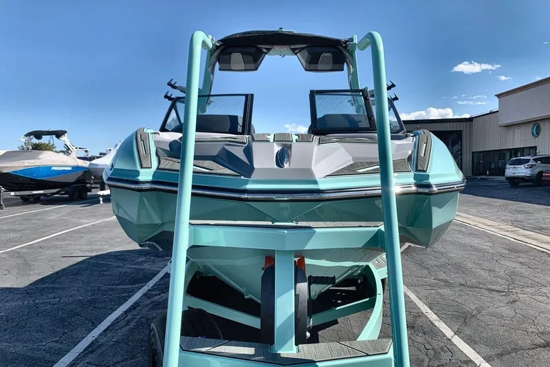 Slide: The Image of 2026 Supra SL 550 boat in a parking lot, front view with clear blue sky. - 8