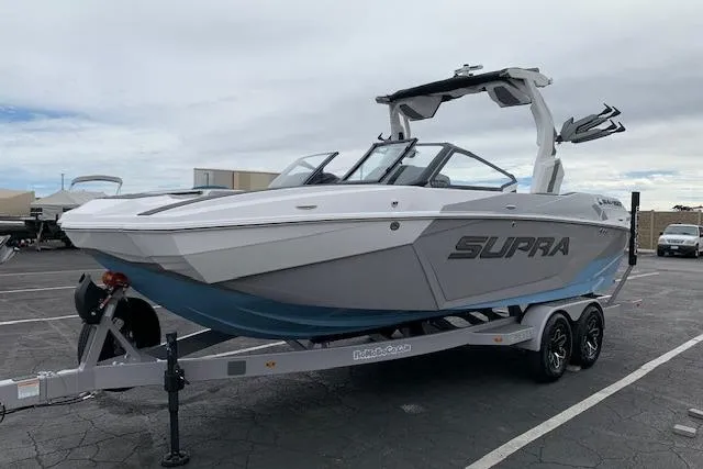 The Image of 2026 Supra SA 450 boat on trailer in parking lot, showcasing sleek design and modern features. - 1