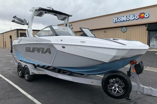 Slide: The Image of 2026 Supra SA 450 boat on trailer, parked outside a building. - 7