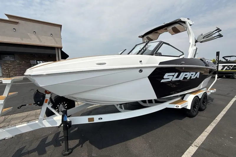 The Image of 2025 Supra SA 550 boat on trailer, sleek design, parked outdoors. - 1