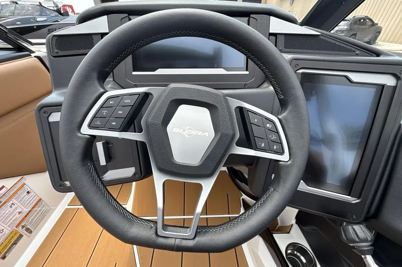 Slide: The Image of Steering wheel of 2025 Supra SA 550 boat with modern dashboard controls. - 14