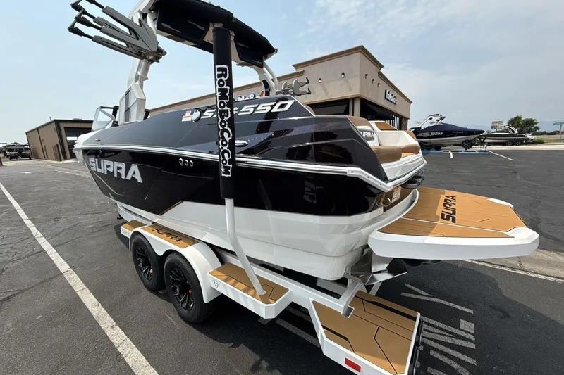 Slide: The Image of 2025 Supra SA 550 boat on trailer, parked outside dealership, showcasing sleek design. - 3