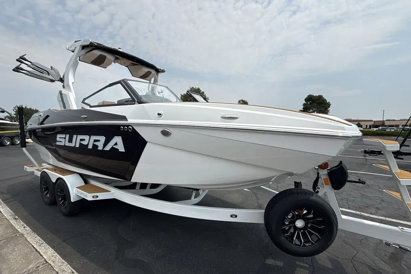 Slide: The Image of 2025 Supra SA 550 boat on trailer, sleek design, white and black exterior. - 7