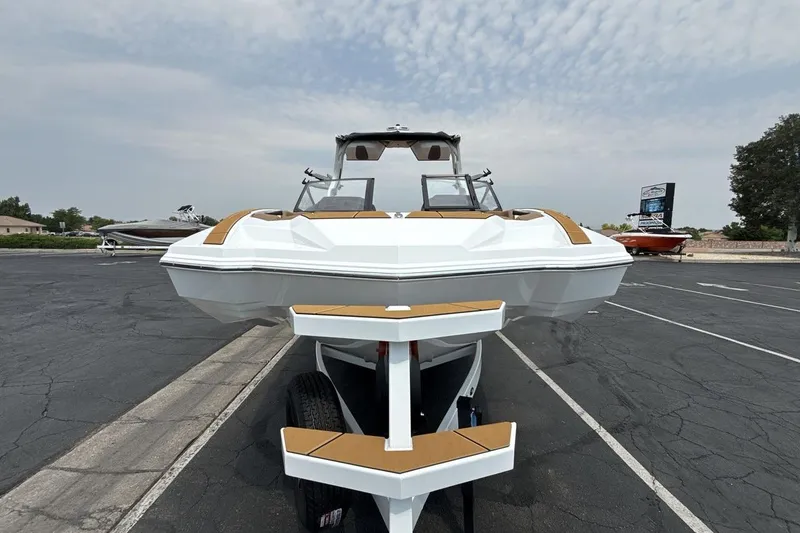 Slide: The Image of 2025 Supra SA 550 boat on trailer in parking lot, front view. - 8
