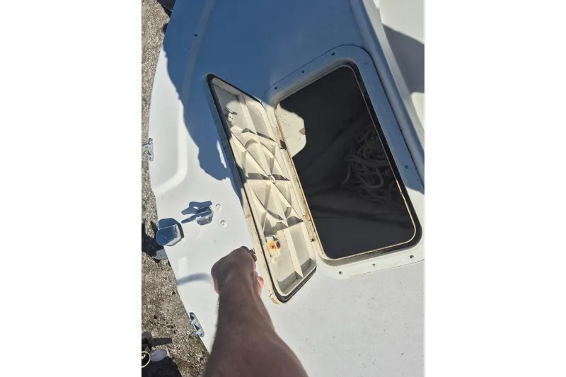 Slide: The Image of Open hatch on 1993 Dusky 227 Open Fisherman boat, revealing storage compartment. - 11