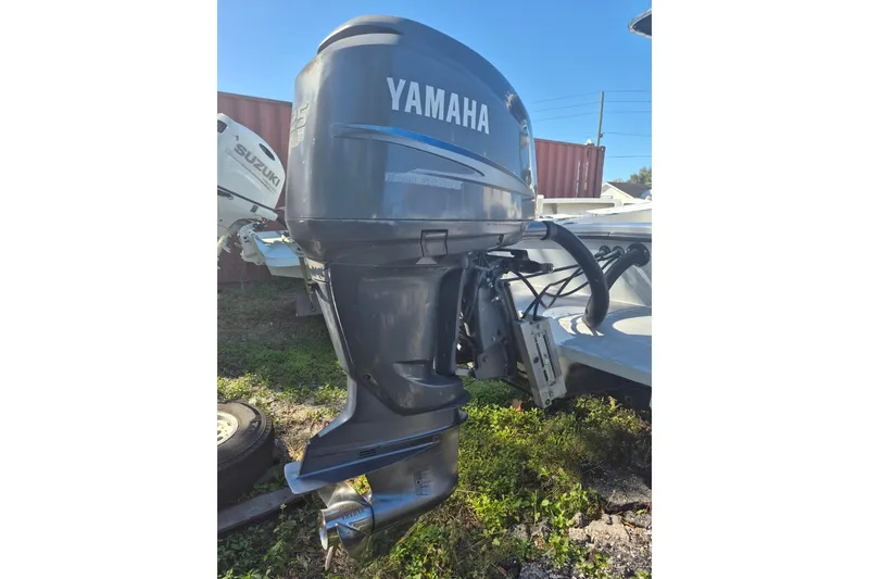 Slide: The Image of Yamaha outboard motor on a 1993 Dusky 227 Open Fisherman boat, parked outdoors. - 5