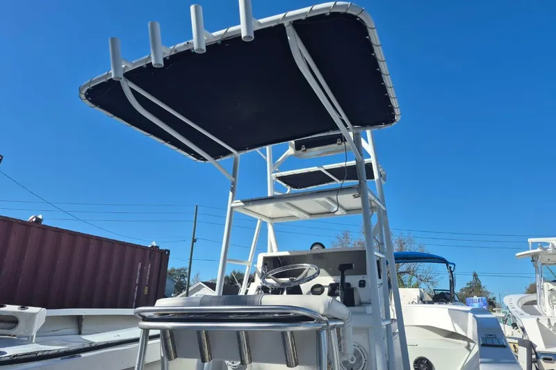 Slide: The Image of 1993 Dusky 227 Open Fisherman boat with T-top and rod holders, under clear blue sky. - 7