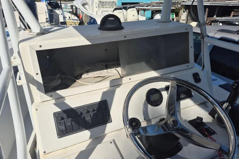 Slide: The Image of 1993 Dusky 227 Open Fisherman boat dashboard with steering wheel and control panel. - 9