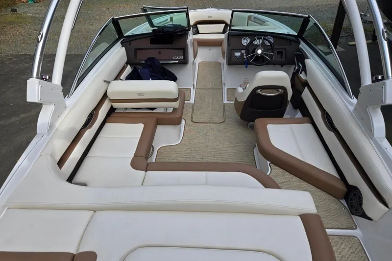 Slide: The Image of 2018 Cobalt CS23 boat interior with beige and brown seating, steering wheel, and dashboard. - 14