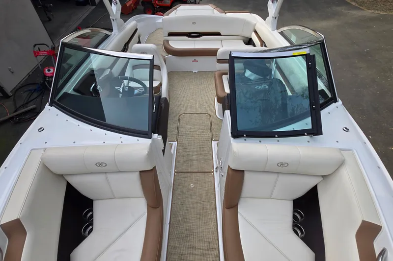Slide: The Image of 2018 Cobalt CS23 boat interior with white and brown seating, open cockpit view. - 15