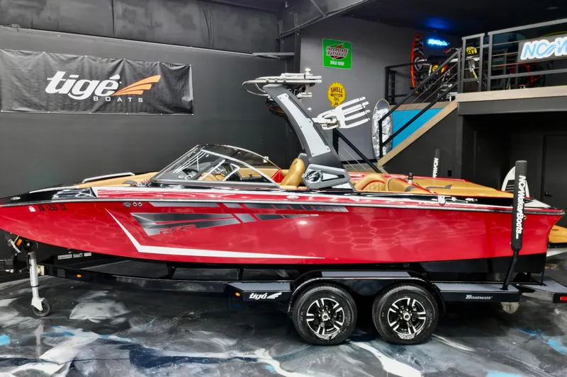 The Image of 2017 Tigé RZX2 boat in showroom, red exterior, displayed on trailer. - 1