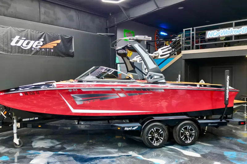 Slide: The Image of 2017 Tigé RZX2 boat in showroom, vibrant red color, displayed on trailer. - 5