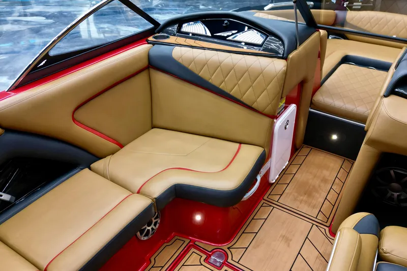 Slide: The Image of 2017 Tigé RZX2 boat interior with tan and red upholstery, featuring quilted seats and wood-patterned flooring. - 11