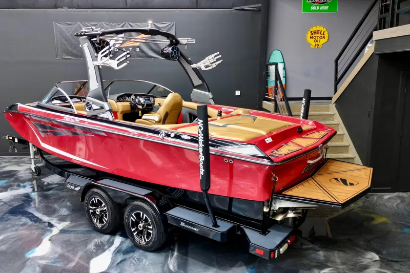 Slide: The Image of 2017 Tigé RZX2 boat in showroom, red exterior, tan interior, on trailer. - 3