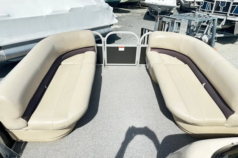 Slide: The Image of 2018 Sun Tracker Party Barge 18 DLX interior with beige seating and open deck layout. - 17