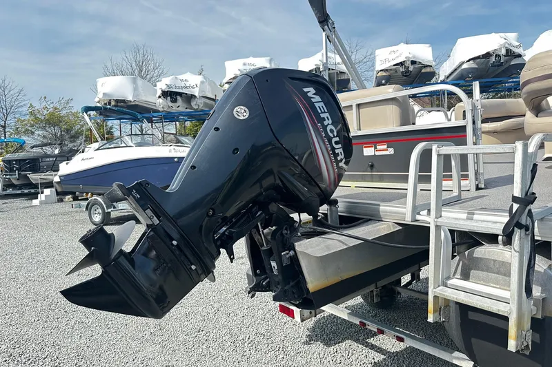 Slide: The Image of 2018 Sun Tracker Party Barge 18 DLX with Mercury outboard motor in a boatyard. - 23