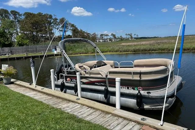 Slide: The Image of 2018 Sun Tracker Bass Buggy 18 Classic pontoon boat docked by a scenic riverside. - 4